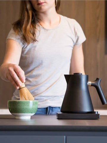 FELLOW Corvo EKG Electric Kettle on counter top with lady